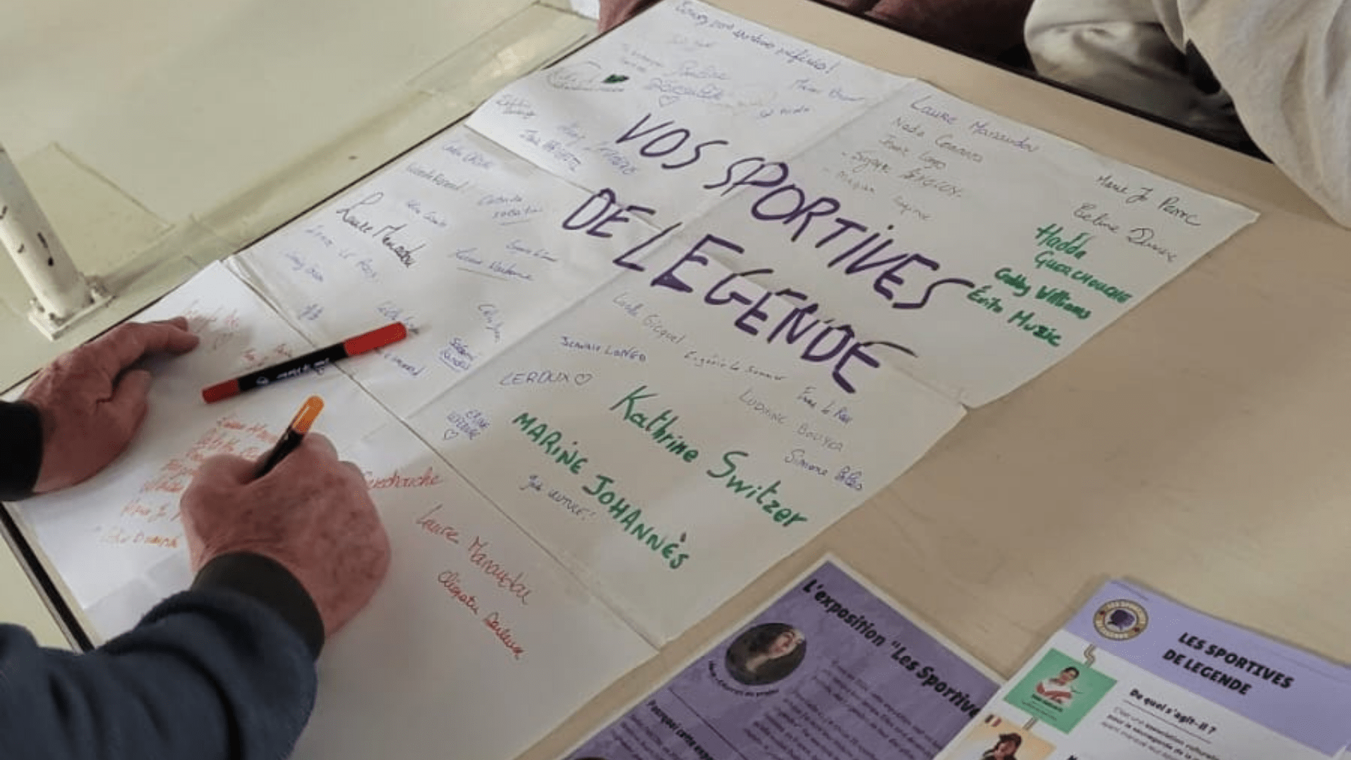 Personne écrivant sur la fresque collaborative lors d'une animation